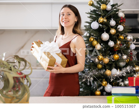 Cheerful woman poses against the background of a Christmas tree 100515307