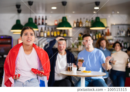 Company of young adult sports supporters with national flag of England upset about favorite team losing match in bar Company of young adult sports supporters with national flag of England upset about favorite team losing match in bar 100515315