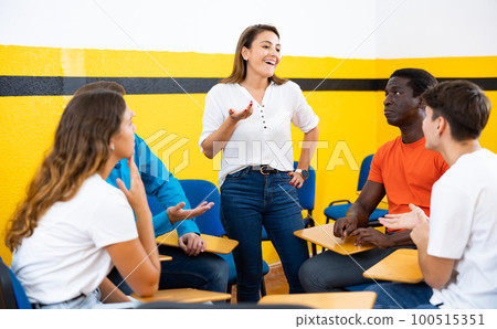 Female student discussing with groupmates sitting in circle in auditorium during classes Female student discussing with groupmates sitting in circle in auditorium during classes 100515351