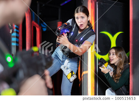 Girl running and dodging while playing lasertag Girl running and dodging while playing lasertag 100515653