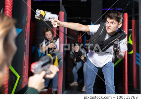 Excited teenager having fun playing lasertag in arena Excited teenager having fun playing lasertag in arena 100515769