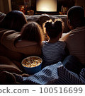 a family watching tv together on the couch with popcorn in their hands and two children sitting next to each other people 100516699
