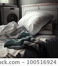 an unmade bed with two pillows and a washing machine in the background, all on top of each other items 100516924