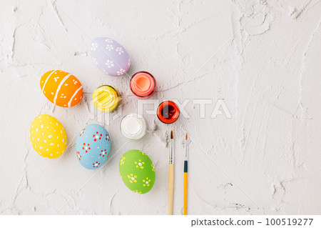 Easter Day Concept. colored multi-colored and paints brush painting easter eggs, colorful paints and paint brushes isolated on white cement background with copy space for text Easter Day Concept. colored multi-colored and paints brush painting easter eggs, colorful paints and paint brushes isolated on white cement background with copy space for text 100519277
