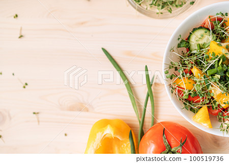 Vegetable salad with microgreens near ingredients on wooden table Vegetable salad with microgreens near ingredients on wooden table 100519736