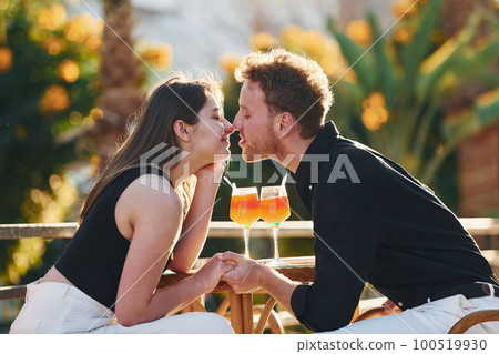 Closeness of the people. Happy young couple is together on their vacation. Outdoors at sunny daytime Closeness of the people. Happy young couple is together on their vacation. Outdoors at sunny daytime 100519930