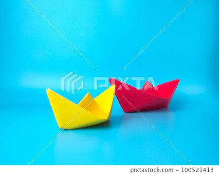 Leadership concept. Red leader paper ship leading among others on blue background... 100521413