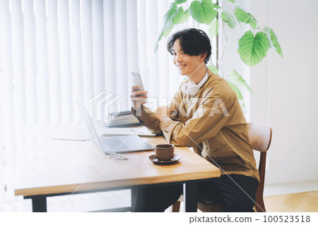 看著智能手機的男人 100523518