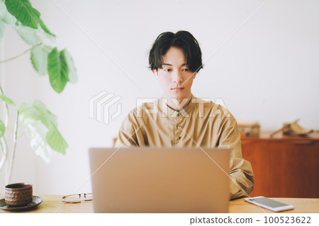 戴耳機看電腦的男人 100523622