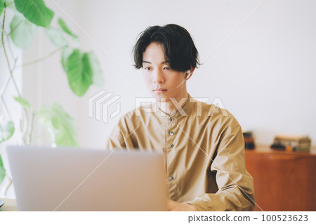 戴耳機看電腦的男人 100523623