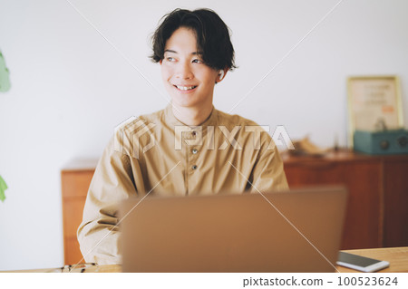 戴耳機看電腦的男人 100523624