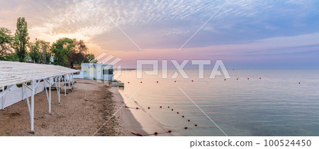 Tranquil Beach Sunrise. Closeup sea sand beach. Beautiful panoramic landscape, colorful golden sunrise over calm sea with waves 100524450