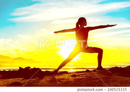 Yoga well-being woman training outdoors in morning sunrise. Wellness and health concept. Silhouette againts sun sky. Yoga well-being woman training outdoors in morning sunrise. Wellness and health concept. Silhouette againts sun sky. 100525155