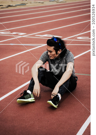 完成後坐在田徑跑道上的男賽跑者 100526934