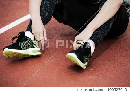 完成後坐在田徑體育場跑道上的跑步者 100527643