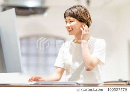 回國後在家打工的穿T恤的年輕女子 回國後在家打工的穿T恤的年輕女子 100527779