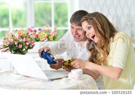 young couple at table and playing video game 100529185
