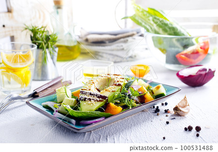 Green vegan salad with cucumber and avocado on a concrete table. View from above. Green vegan salad with cucumber and avocado on a concrete table. View from above. 100531488