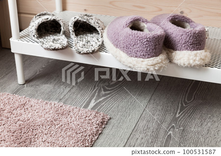 Woolen slippers stand on a white shelf 100531587