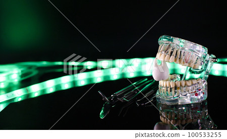 Dental tools and model of teeth on a neon background. Dental care concept. Invisible braces Dental tools and model of teeth on a neon background. Dental care concept. Invisible braces 100533255