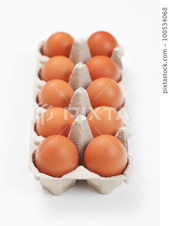 Raw brown organic eggs in paper tray on white with yolk inside Raw brown organic eggs in paper tray on white with yolk inside 100534068