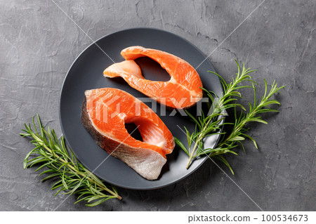 Steak of fresh raw red fish salmon with lemon, rosemary and pepper on black background 100534673