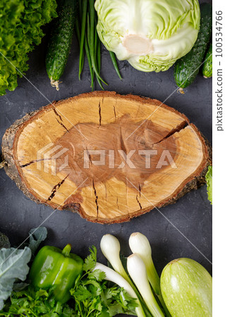 Border of green raw vegetables around empty cutting board. Place for your product or text. Border of green raw vegetables around empty cutting board. Place for your product or text. 100534766