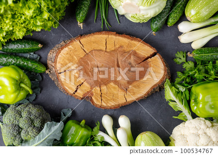 Border of green raw vegetables around empty cutting board. Place for your product or text. Border of green raw vegetables around empty cutting board. Place for your product or text. 100534767