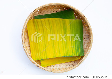 Yellow green banana leaf in bamboo basket on white background. Yellow green banana leaf in bamboo basket on white background. 100535045