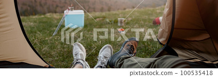 View from inside the tent on beautiful landscape of mountains. Couple lying in camp at nature. 100535418