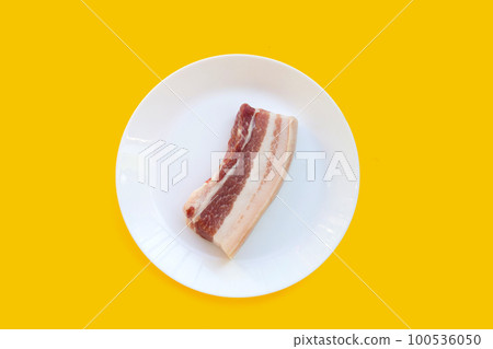 Streaky pork in white plate on yellow background. Streaky pork in white plate on yellow background. 100536050