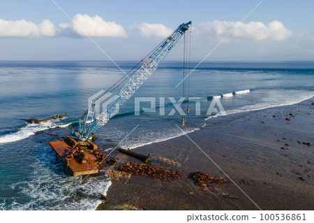 Aerial view of abandoned construction crane over the sea 100536861