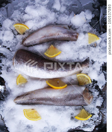 Fresh raw sea fish and lemon peces on ice surface. Fresh raw sea fish and lemon peces on ice surface. 100537893