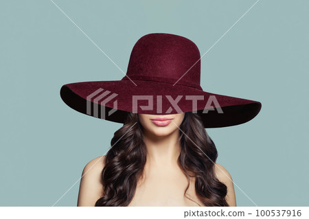 Nice woman in wide red hat on blue background 100537916