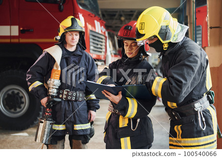 With notepad. Group of firefighters in protective uniform that is on station 100540066