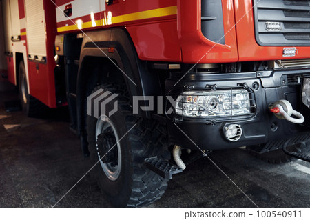 Close up view of front part of red fire truck. Natural lighting 100540911