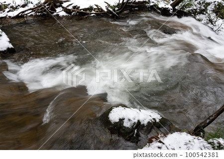 流經白雪覆蓋的森林的山間溪流 流經白雪覆蓋的森林的山間溪流 100542381