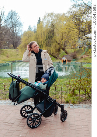 Happy boy sitting in a stroller with mom Happy boy sitting in a stroller with mom 100545698