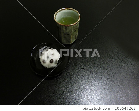 Bean mochi and tea on a plate 100547265