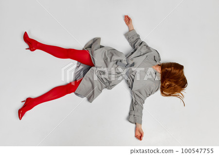 Impersonal human emotions. Stylish girl in grey coat and bright red tights moves over light background. Expressive fashion. Concept of art photography, beauty 100547755