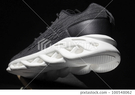 Black fabric sneakers with a white sole on a black background. 100548062