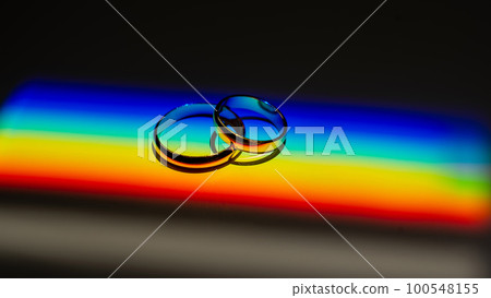 Rainbow beam on wedding rings. lgbt flag.  100548155