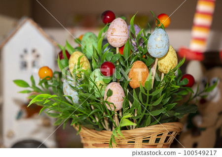 Easter basket with green grass and handmade decorative eggs. 100549217
