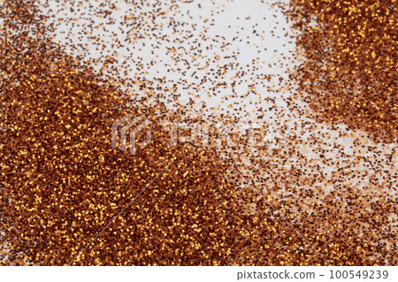 Golden sequins are scattered on a white background. Golden sequins are scattered on a white background. 100549239