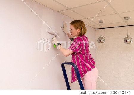 Redecorating. Painting walls with paint-roller Redecorating. Painting walls with paint-roller 100550125