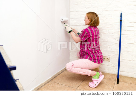 Redecorating. Painting walls with paint-roller 100550131