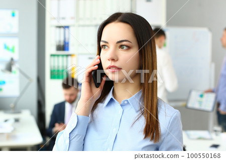 Portrait of beautiful businesswoman with phone in office Portrait of beautiful businesswoman with phone in office 100550168