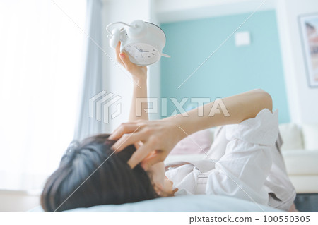 A woman looking at a clock Lifestyle A woman looking at a clock Lifestyle 100550305