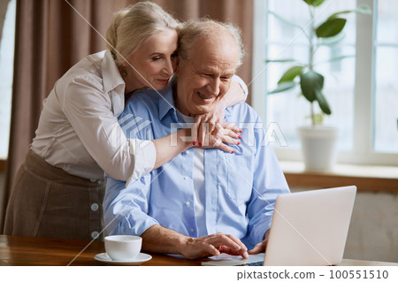 Delightful senior couple, mature man and woman working o laptop at home. Online shopping, communication, paying bills online 100551510
