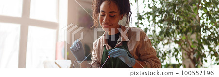 Happy smiling woman florist making succulent plant composition at floral design studio Happy smiling woman florist making succulent plant composition at floral design studio 100552196